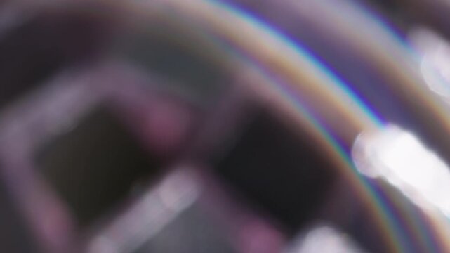 Defocused reflection leak. Light swirling. Colorful arch ring flash in silver glass stroboscopic ball. Abstract spectrum twinkle art background.