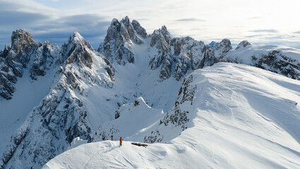 Fototapeta premium Beautiful Winter Dolomite Mountain Scenery with Man on Cross-Country Skis , Aerial View