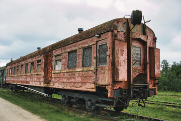 Fototapeta premium Abandoned Vintage Rusty Train Carriage on Overgrown Tracks