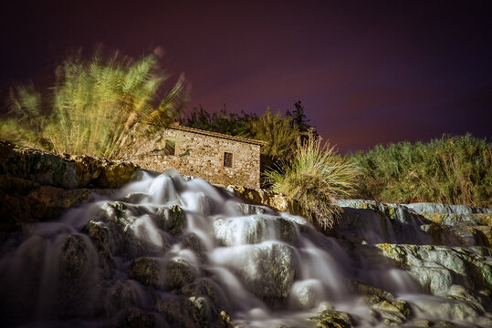 Cascate del Mulino di Saturnia thermal baths, Tuscany, Italy: Stone building by waterfall at night