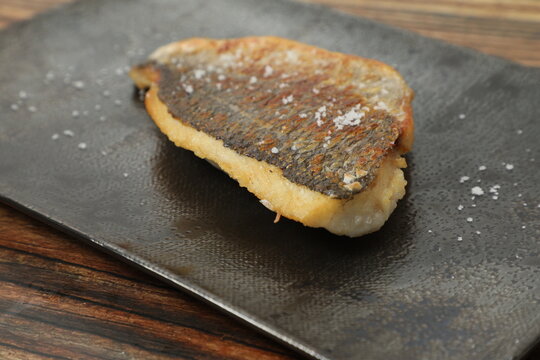 Poisson grill&eacute; sur une assiette en bois