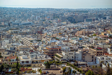 Fototapeta premium Athens, Greece: Aerial view of dense city buildings and ocean horizon