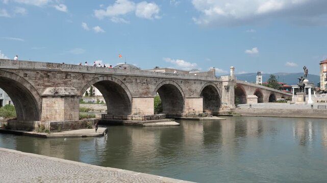 Skopje, North Macedonia - August 6, 2025: Stone bridge over Vardar river, Skopje. Urban construction and city infrastructure in Central Municipality in capital of Macedonia.