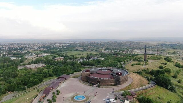 Aerial drone view of the historic Black Fortress, Sev Berd, and the Mother Armenia statue in Gyumri. The video shows the monumental architecture and the surrounding city landscape.