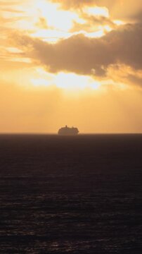 Vertical view of a large cruise ship at sea during golden hour, Madeira