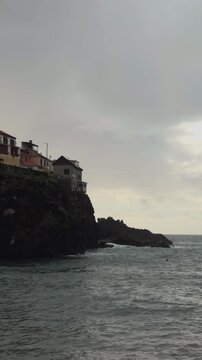 Dramatic coastline of C&acirc;mara de Lobos village on volcanic cliffs, Apple Log 2 4K