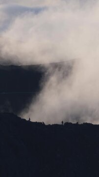 Dramatic silhouettes of people trekking along volcanic cliffs at sunrise, Pico do Arieiro