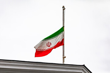 Obraz premium The Iranian flag at half-mast on the roof of the embassy building during the mourning period