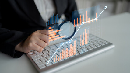 A business professional engages with market data on a laptop, showcasing digital graphs and...