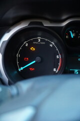 Close-up of a car dashboard with multiple warning lights illuminated, including check engine, battery, and oil pressure icons, signifying mechanical trouble.