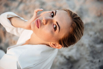 Close-up portrait of a young woman with freckles and soft makeup looking thoughtfully