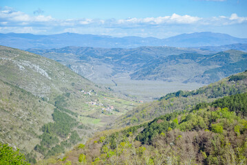 Fototapeta premium Oprtalj, Istria, Croatia: Mountain valley with village and forest under blue sky