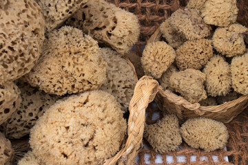 Natural sea sponges in esparto baskets, at a stall in an open-air market.