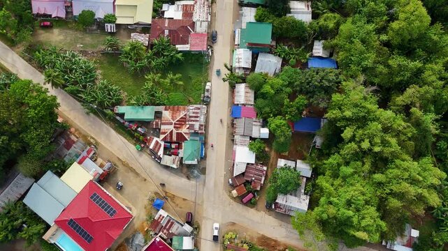 Philippines, Puerto Princesa, 02 May 2025. View of a typical urban street scene with small local businesses, overhead wires, and corrugated rooftops during dusk.