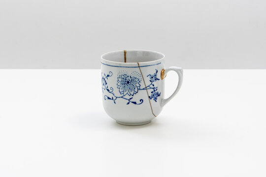 alter Kaffeebecher mit Henkel, blau wei&szlig; gemustert mit neuem Kintsugi repariert