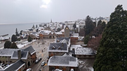 snow in Bariloche's main square, with Alpine-inspired architecture and the cathedral tower in the background. San Carlos de Bariloche, Patagonia, Argentina. Andes Mountains