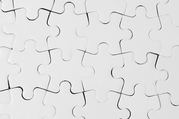 Fototapeta premium Top-Down View of Connected White Jigsaw Puzzle Pieces 