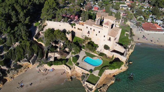 Orbital drone footage of Tamarit castle and beach on sunny day. Tamarit, Tarragona, Spain.