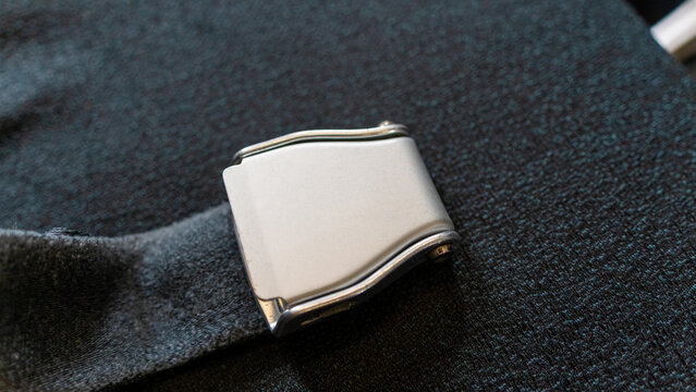 Essential aviation safety gear featuring a close up of an unbuckled silver airplane seat belt.