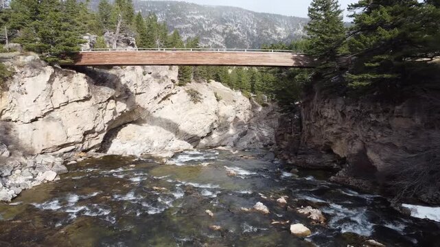 Fly under wooden bridge mountain gorge 