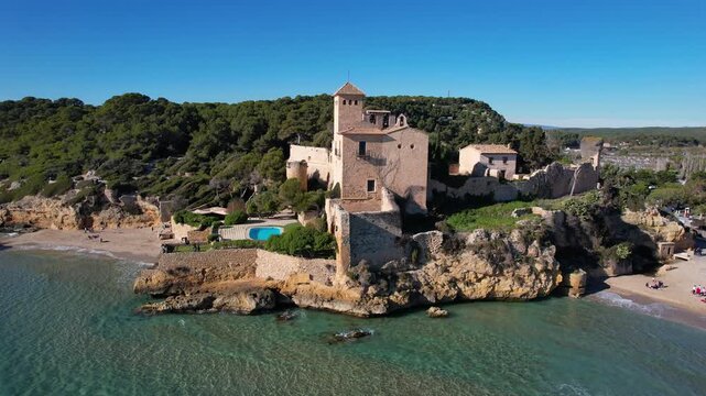 Orbital aerial shot of Tamarit castle on sunny day. Tamarit, Tarragona, Spain.