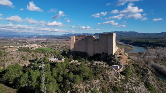 Rising up aerial shot of Miravet castle on sunny day. Tarragona, Spain.