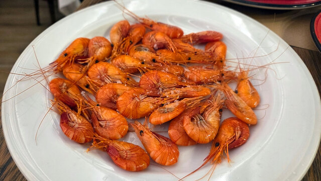 Delicious caridean shrimp platter on a white plate for seafood lovers. Spanish traditional food. Camaron, quisquilla, caridea