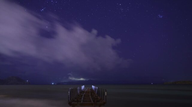 A ruined pier after a storm, and timelapse footage of stars and clouds in the sky. Lightning and thunder over islands in the Aegean Sea. A suitable video for meteor showers.