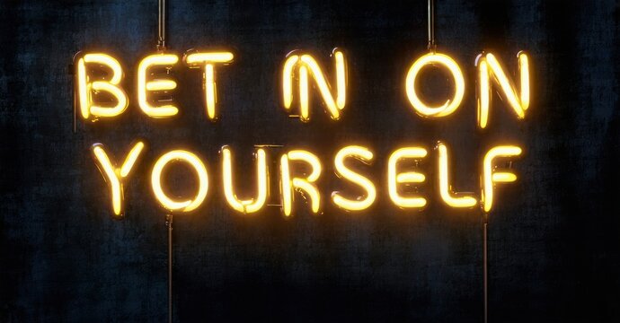 Bright neon sign displays motivational phrase Bet On Yourself. Dark background emphasizes glowing text, creating bold statement.