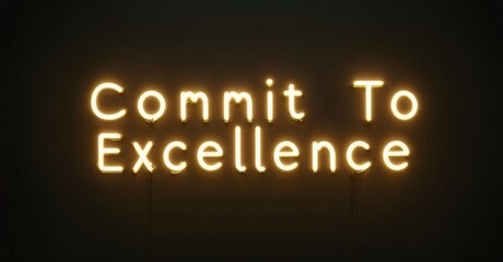 Fototapeta premium Bright neon sign displays text Commit To Excellence against dark background. Simple, motivational message radiates warmth.