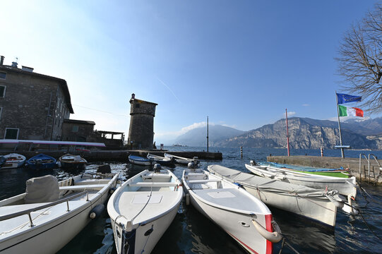 Boats by the historic tower on Lake Garda