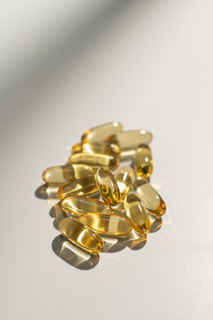 Vitamin supplements in soft gel capsules on white