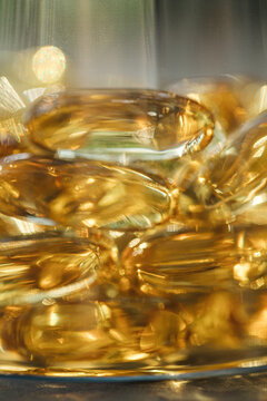 Close-up of golden vitamin D supplements in bottle