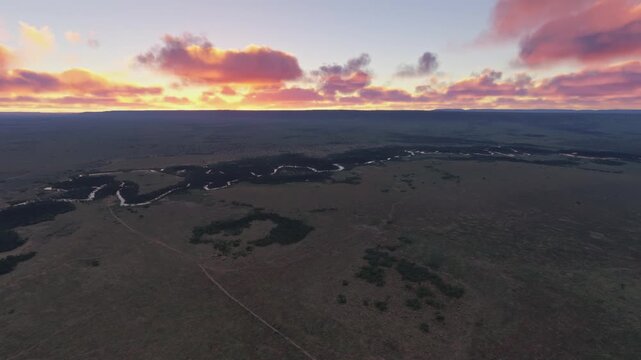 Side aerial drone shot at sunset of Mara River in Narok County. Kenya