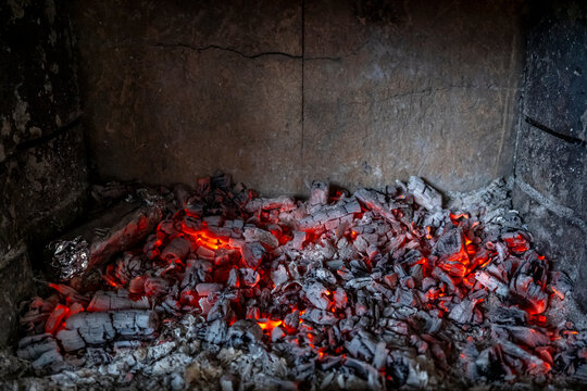 Glowing embers and ashes in a fireplace setting