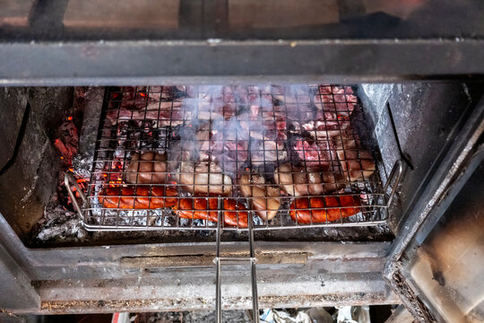 Grilling assorted meats over open flames