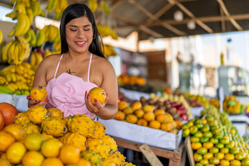 Obraz premium Woman selling fresh pitahaya and tropical fruits at market