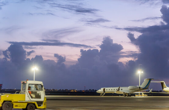Dusk view at Faro airport runway with plane and vehicle