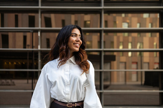 Confident hispanic businesswoman outside modern building
