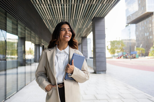 Confident hispanic businesswoman with tablet in city