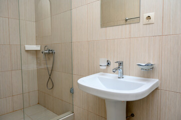 Fototapeta premium Modern bathroom interior with shower, sink, and tiled walls