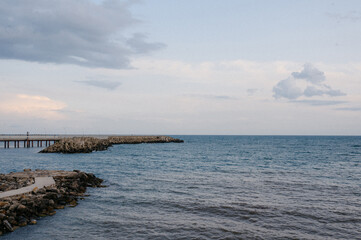 Coastal view with rocky shoreline and pier extending into the ocean