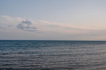 Obraz premium Calm ocean waves under a cloudy sky during twilight hours