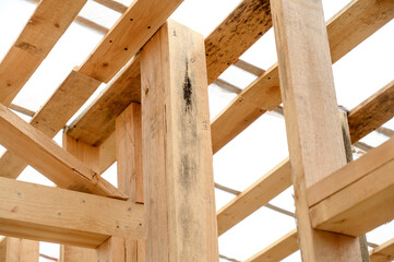 Wooden beams and framework structure under construction in bright light
