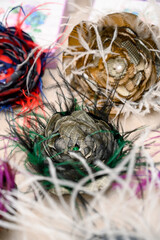 Colorful handmade fabric flowers with feathers on display for sale