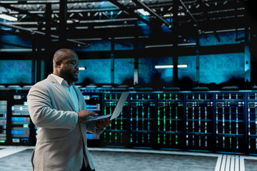 Data center software developer using laptop to protect servers from exploitable software...