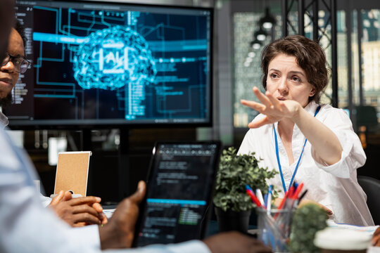 Data scientists in artificial intelligence startup office brainstorming, building scalable solutions for businesses. Coworkers doing meeting to discuss deep learning tech implementation in office