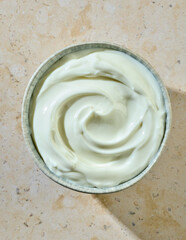 bowl of fresh greek yogurt on kitchen table, top view