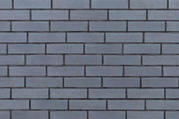 Fototapeta premium Textured grey surface resembling brick masonry, industrial style backdrop
