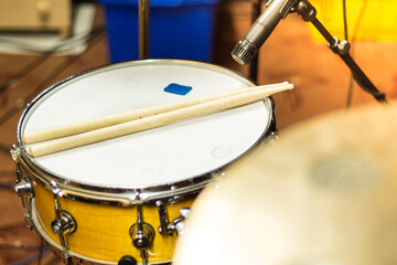 Obraz premium Snare drum with drumsticks and microphone in a studio setup